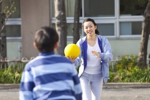 ドッヂボールをする小学生男子と女性教師